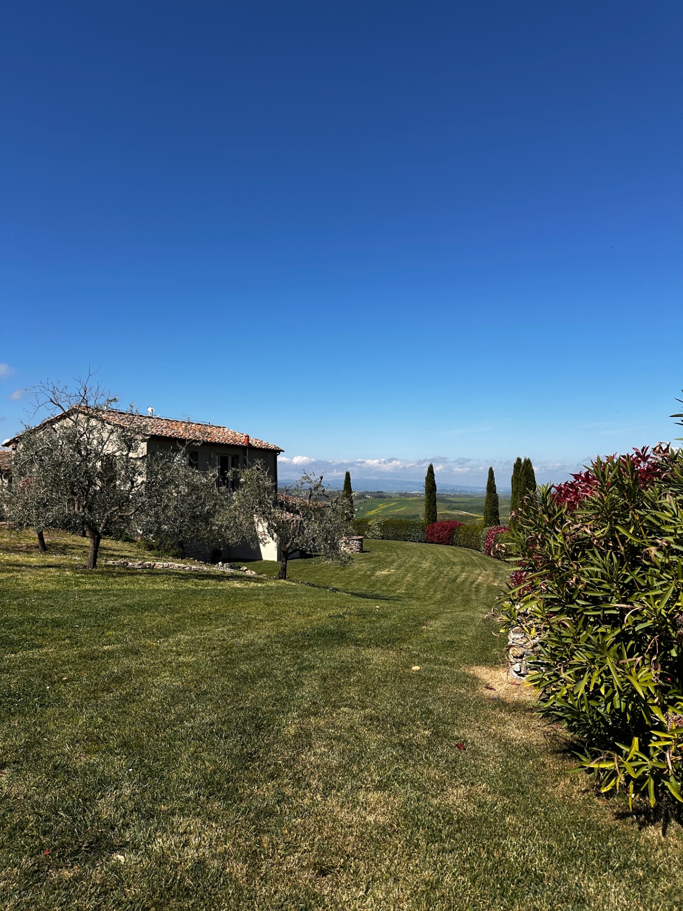 Le Capanne gardens with rolling Tuscan views
